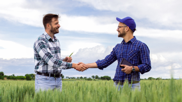 Two men shaking hands in a field